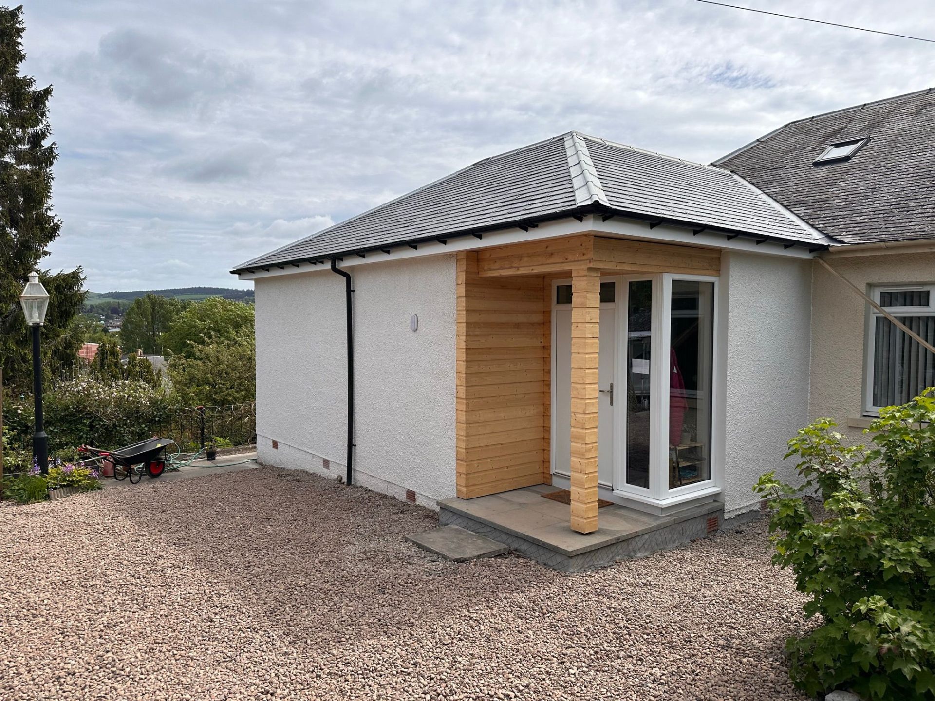Rendered single-storey extension with cedar porch